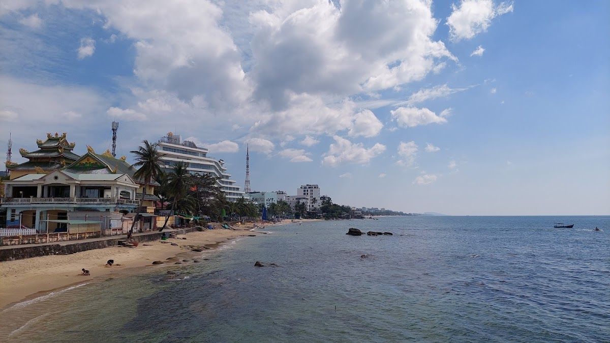 Duong Dong town waterfront with the Dinh Cau rock temple, sandy beach, and hotels along the northern end of Long Beach in Phu Quoc
