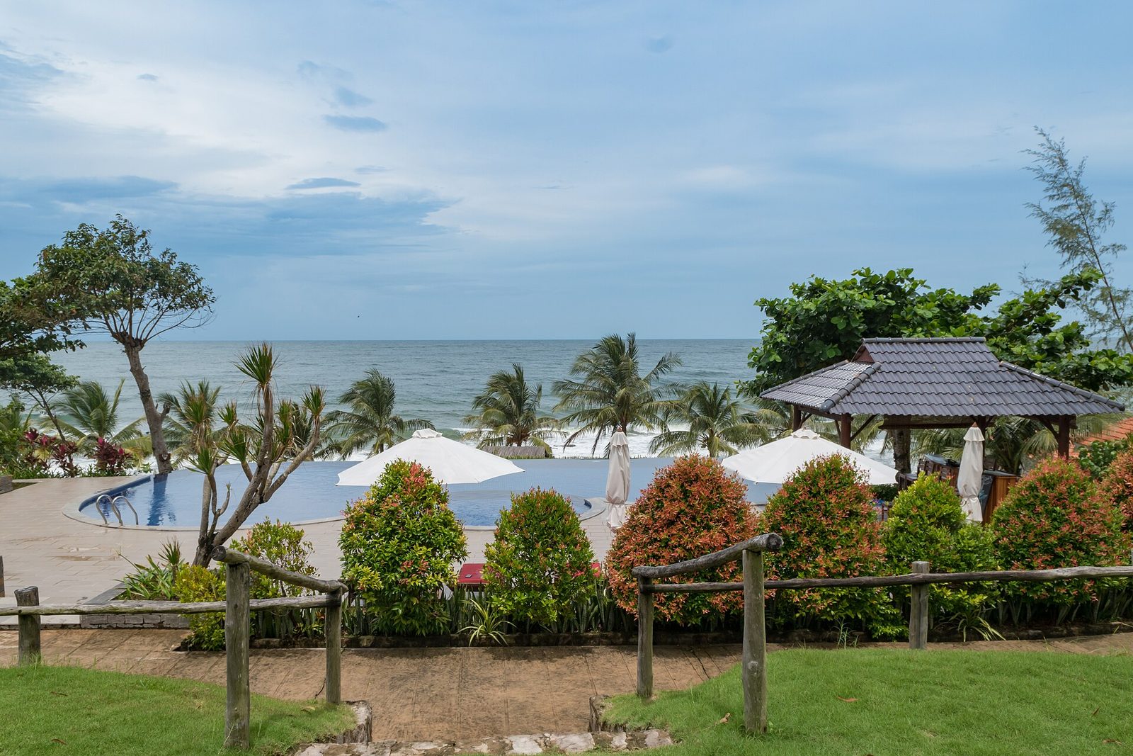 An infinity pool facing the sea at a Phu Quoc resort, with loungers and palms along the deck