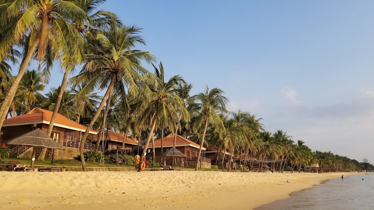Golden sand beach at Long Beach (Bai Truong) Phu Quoc with leaning palm trees and beachfront resort bungalows stretching along the west coast