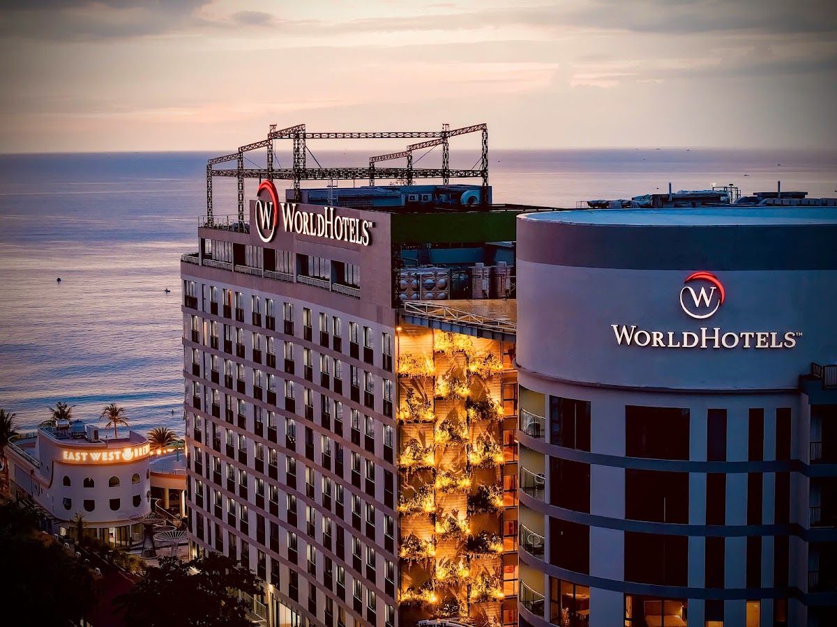 A beachfront hotel tower lit up at dusk on the Phu Quoc coastline