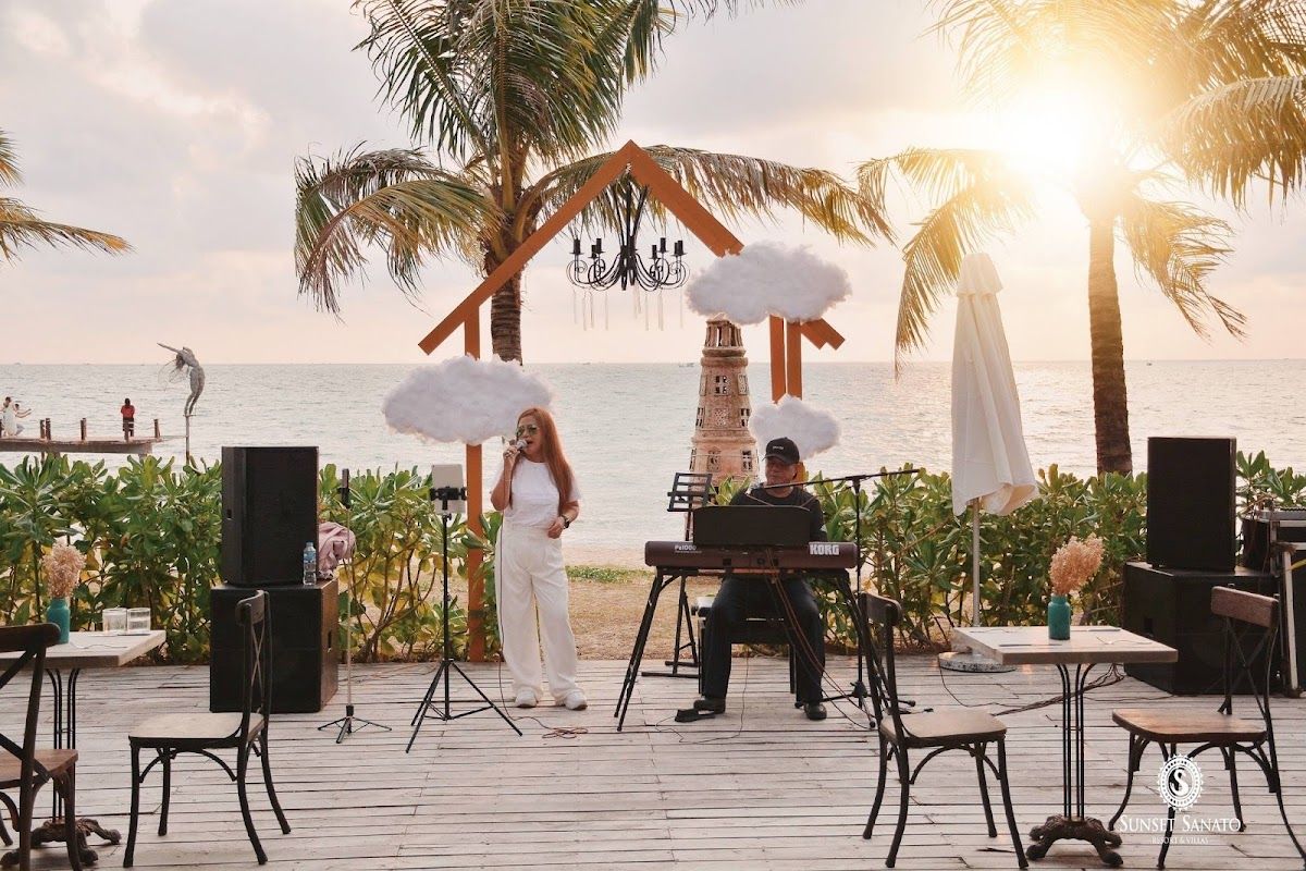 Sunset Sanato Beach Club on Long Beach, with art installations and beachfront seating at dusk